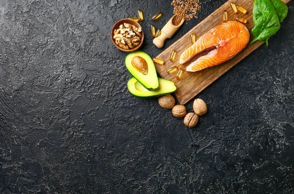 Conjunto de produtos saudáveis com alto ómega 3 e pílulas de óleo de peixe em fundo escuro — Fotografia de Stock