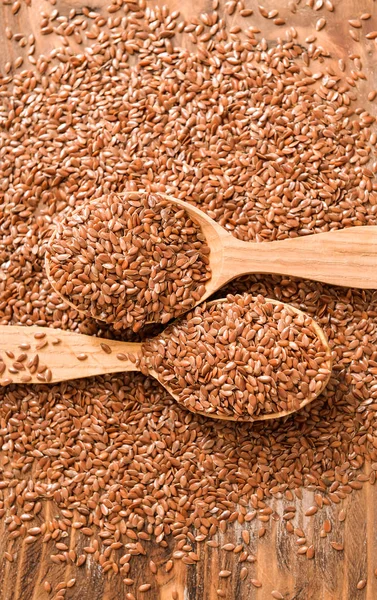 Spoons with flax seeds on wooden background — Stock Photo, Image