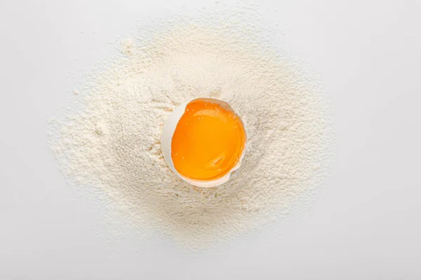 Ovo de galinha cru e farinha no fundo branco — Fotografia de Stock
