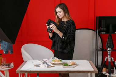 Genç bir kadın profesyonel stüdyoda makarna fotoğrafı çekiyor.