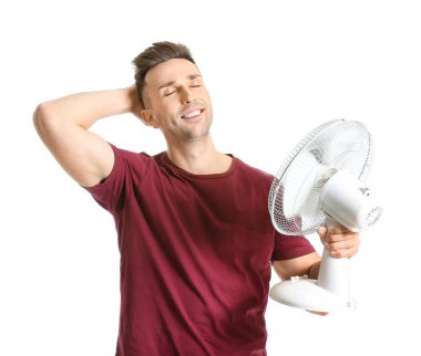 Young man with electric fan on white background