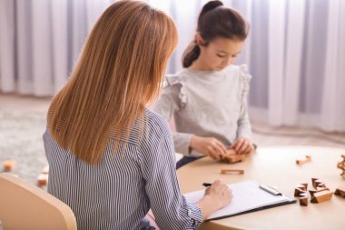 İçeride küçük bir kızla çalışan psikolog.