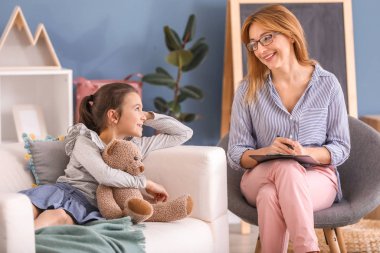 İçeride küçük bir kızla çalışan psikolog.