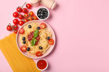 Renkli makarna, zeytin ve domates soslu tabak.