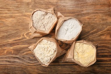 Ahşap zemin üzerinde farklı un olan torbalar.