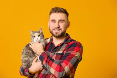 Renkli arka planda sevimli kedisi olan adam