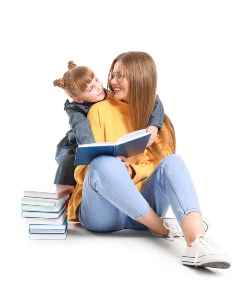 Piękna młoda kobieta i jej córeczka czytają książki na białym tle — Zdjęcie stockowe