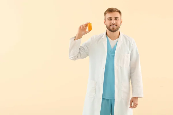 Portrait of male doctor with pills on light background — Stock Photo, Image