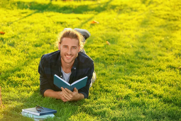 Knappe man die buiten een boek leest — Stockfoto