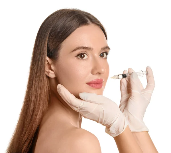 Mulher jovem recebendo injeção de enchimento contra fundo branco — Fotografia de Stock
