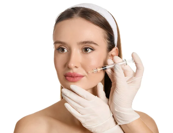 Young woman receiving filler injection against white background — Stock Photo, Image