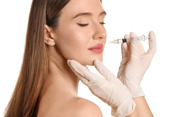 Young woman receiving filler injection against white background — 스톡 사진