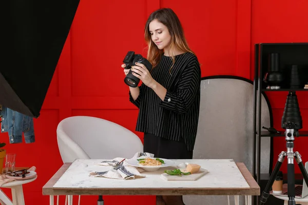 Young woman taking picture of pasta in professional studio — Stock Photo, Image