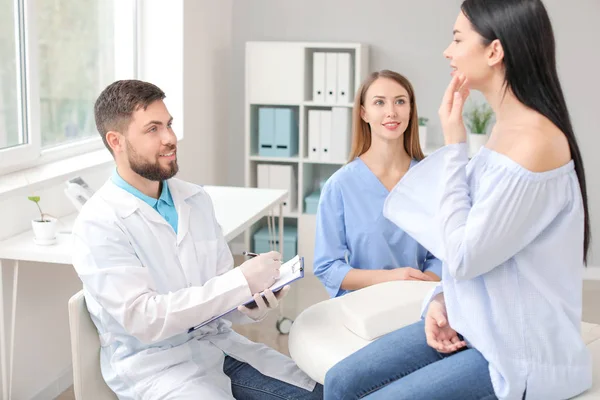 Beautiful woman meeting with plastic surgeon in clinic — Stock Photo, Image