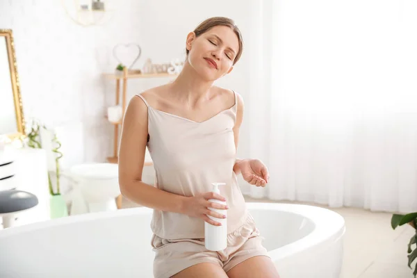 Beautiful pregnant woman with body cream in bathroom — 스톡 사진