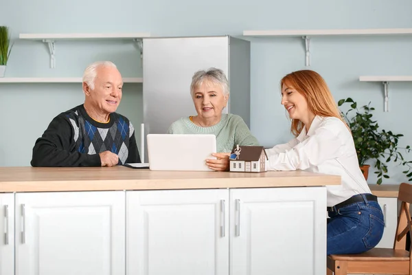 Agente immobiliare femminile che lavora con coppie anziane al chiuso — Foto Stock