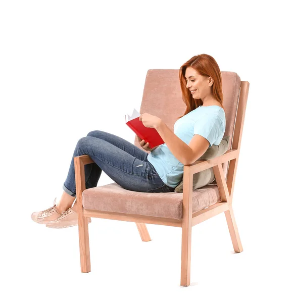 Красивая женщина читает книгу, сидя в кресле на белом фоне — стоковое фото