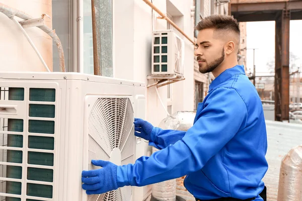 Muž technik instalace venkovní jednotky klimatizace — Stock fotografie