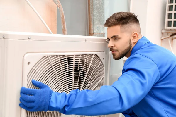 Muž technik instalace venkovní jednotky klimatizace — Stock fotografie