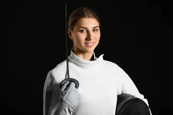 黑暗背景下的年轻女击剑运动员 — 图库照片