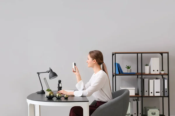 Young woman working in office with operating air conditioner — Stock Photo, Image