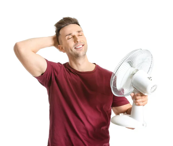 Young man with electric fan on white background — Stok fotoğraf