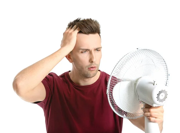 Confused man with electric fan on white background — Stock Photo, Image