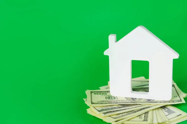 Figurka domu s dolarovými bankovkami na barevném pozadí. Koncept nákupu nemovitostí — Stock fotografie