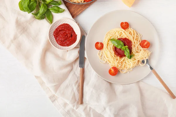 Тарілка зі смачною макаронами та томатним соусом на білому тлі — стокове фото