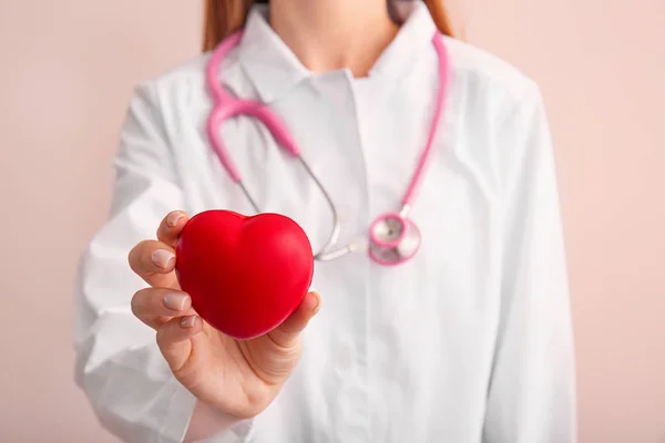 Cardiolog feminin cu inima roșie pe fundal de culoare, closeup — Fotografie, imagine de stoc