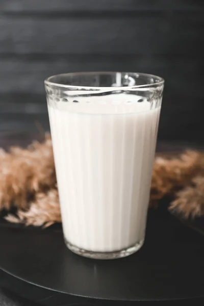 Verre de lait savoureux sur table noire — Photo