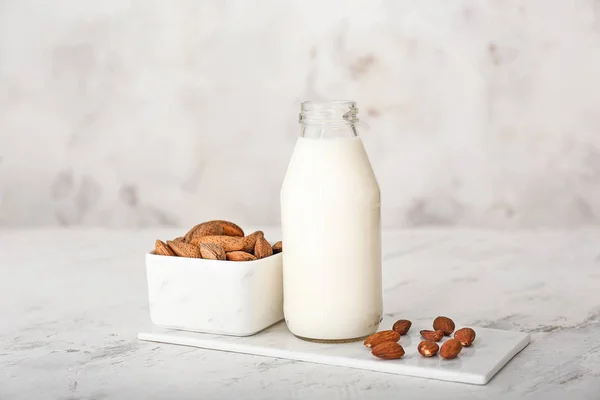 Bottiglia di gustoso latte di mandorla su sfondo bianco — Foto Stock