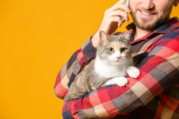 Homme avec chat mignon parlant par téléphone sur fond de couleur — Photo