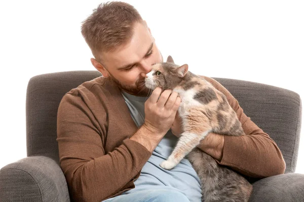 Man with cute cat sitting in armchair against white background — Stock Photo, Image