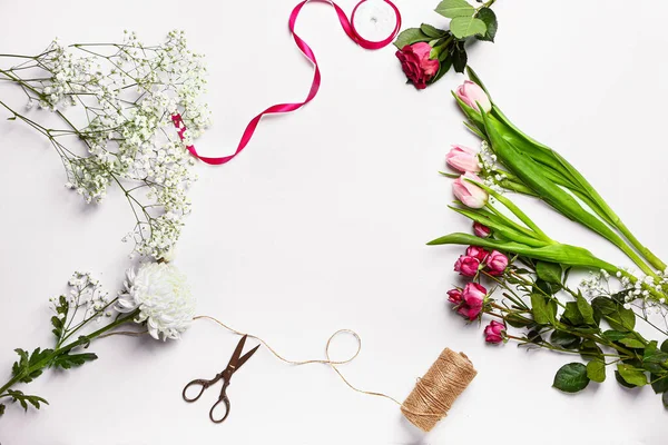 Frame made of supplies of florist with fresh flowers on white background — Stock Photo, Image