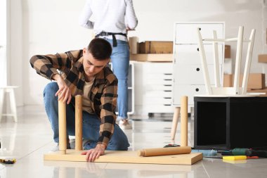 Tamirci atölyede mobilya montajı yapıyor.