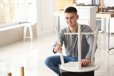 Tamirci atölyede mobilya montajı yapıyor.