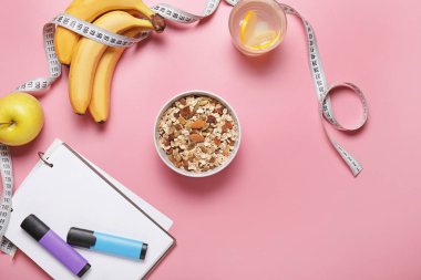 Different healthy food with measuring tape and notebook on color background. Diet concept