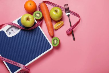 Different healthy food with measuring tape and scales on color background. Diet concept