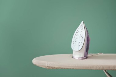 Renk arkaplanında elektrikli ütü ve tahta