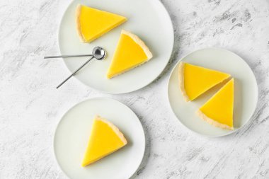 Plates with slices of tasty homemade lemon pie on table