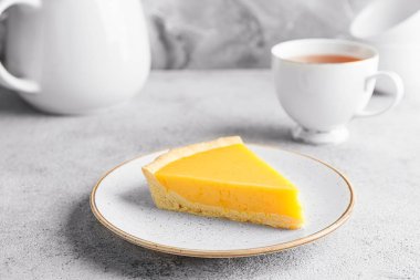 Plate with slice of tasty homemade lemon pie on table