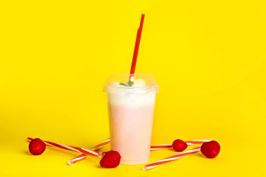 Cup of tasty milkshake on color background