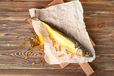 Yağlı balık ve tahta arka planda haplar.