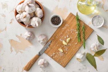 Beyaz arka planda baharatlı, yağlı ve otlu taze sarımsak.