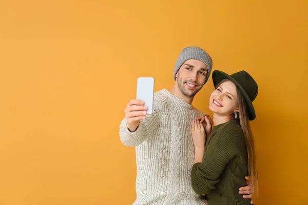 Pareja joven tomando selfie sobre fondo de color — Foto de Stock