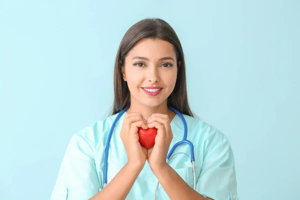 Female cardiologist on color background — Stock Photo, Image