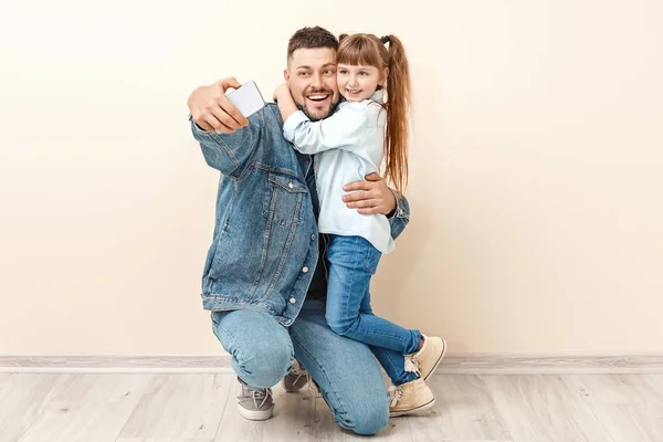 Father and his little daughter taking selfie near light wall — Stock Photo, Image