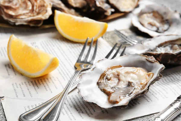 Tasty oysters with lemon on table — Stock Photo, Image