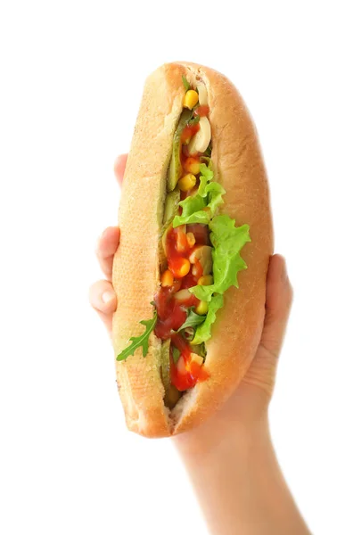 Female hand with tasty hot dog on light background — Stockfoto